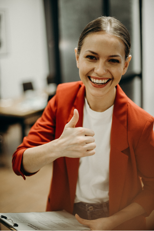 photo of happy woman giving thumbs up for corrective training for employee misconduct program